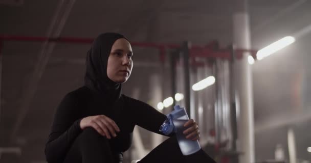 Foto Portátil Atleta Muçulmana Descalça Com Garrafa Água Sentada Tapete — Vídeo de Stock