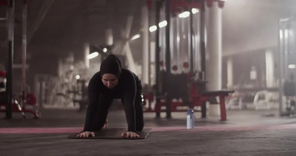 在体育馆进行健身训练时 穆斯林女运动员做 扩展儿童 眼镜蛇 姿势时的手持镜头向后伸展 — 图库视频影像