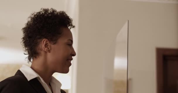 入住宾馆后 站在前台时 有着一头秀丽秀丽卷曲短发的积极优雅的非洲裔美籍成年女性客人的侧影 — 图库视频影像