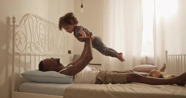 Бічний Погляд Життя Щасливого Афроамериканського Батька Повсякденному Одязі Лежить Ліжку — стокове відео