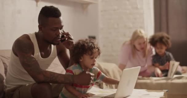 아프리카 미국인 프리랜서 집에서 귀여운 어린이와 근처에서 작업을 소파에 노트북을 — 비디오