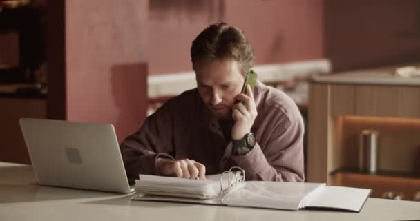 带着手提电脑坐在吧台柜台边 一边做财务报告 一边用手机咨询的大胡子男性创业者的实时手持照片 — 图库视频影像