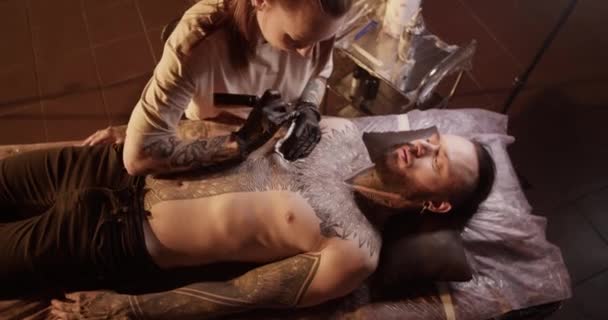 Ovanifrån Professionella Unga Kvinnliga Tatuering Artist Med Långt Hår Latexhandskar — Stockvideo