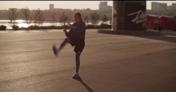 年轻女运动员在晨光下运动前动态伸展时身穿活动服 摆动腿的全身盘 — 图库视频影像