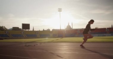 Koşu antrenmanı sırasında spor giyim sektöründe ağır toplarla koşan kararlı genç bir kadının gerçek zamanlı görüntüsü.