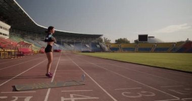 Stadyumdaki işlevsel eğitim sırasında halter omuz presi yapan aktif giyimli güçlü genç bir sporcunun el kamerası görüntüsü.