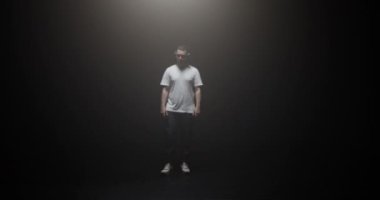 Gerçek zamanlı Kafkasyalı bir adam sahne ışıkları altında dans ediyor. Işıkta görünmüş gibi yapıyor.