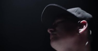 Siyah arkaplana karşı davul çalarken, davul çalarak şapkalı genç ve ilham verici erkek davulcunun