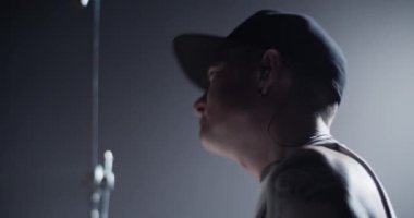 Erkek davulcunun baş sallamasını ve davul setinde müzik çalmasını canlı konser sırasında sahnenin karanlığında izledik.