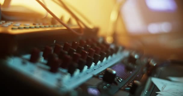 音楽レコーディングスタジオのテーブルに置かれたサウンドミキサーコントロールとノブのクローズアップ — ストック動画