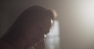 Evde karanlık odada müzik bestelerken masada oturup müzik notaları yazan yetenekli genç bayan müzisyenlerin el kamerasıyla çekilmiş çekimleri.
