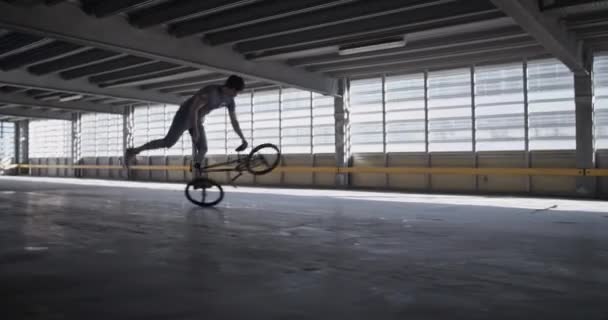 男子Bmx骑手在宽敞停车场进行特技表演时实时平衡盘的极限运动理念 — 图库视频影像