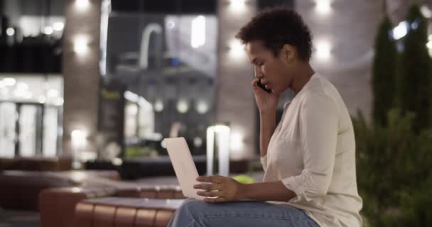 시간에 빛나는 사무실 벤치에 노트북을 비즈니스 문제를 스마트 이야기 아프리카계 — 비디오