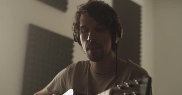 스튜디오에서 공연을 준비하는 기타를 연주하는 헤드폰에 밀레니엄 베어드 뮤지션의 실시간 — 비디오