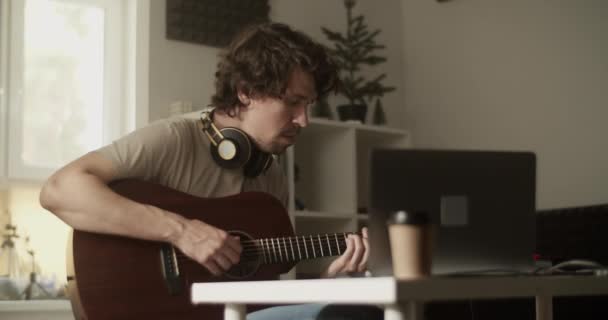Evde Gitar Çalarken Netbook Masada Oturan Sıradan Bir Erkek Sanatçının — Stok video