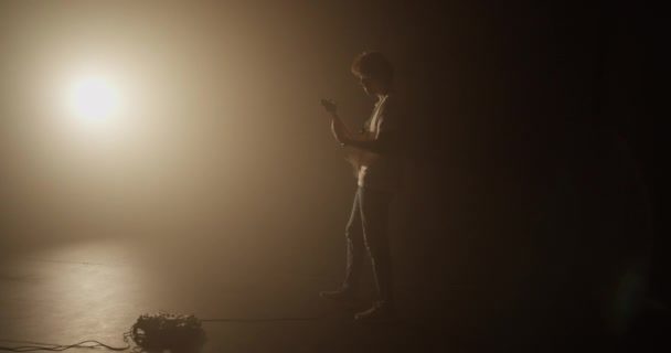 Отслеживание Выстрел Тело Взрослого Мужчины Музыканта Ходьба Темноте Против Светящегося — стоковое видео