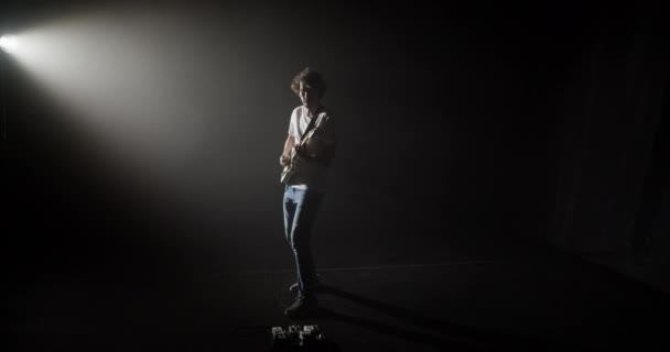 Zoom Cool Modern Man Playing Guitar While Standing Spotlight Dark — Stock Video