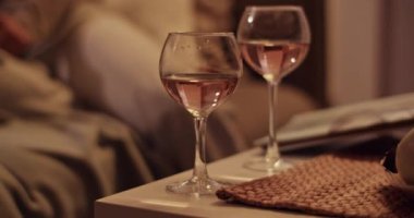 Kanepede kız arkadaşıyla oturan ve akşamları dinlenirken pembe şarapla şarap bardağı içen, el kamerasıyla çekilen...
