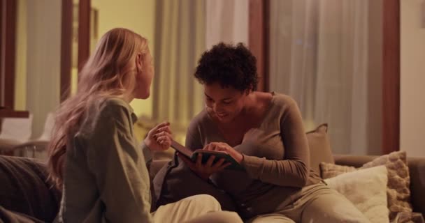 リアルタイムハンドヘルドショット 若い黒人女性の本を読んで 家で一緒に楽しんでいる間ガールフレンドとチャット — ストック動画