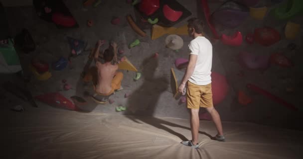 Real Time Back View Trainee Young Male Climber Giving Instructions — Stock Video
