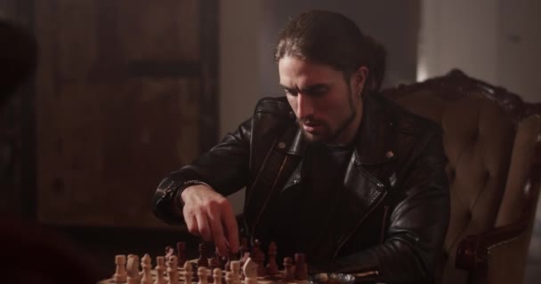 Seriös Vuxen Man Skinnjacka Sittandes Stol Och Spelar Schackbräde Hemma — Stockvideo