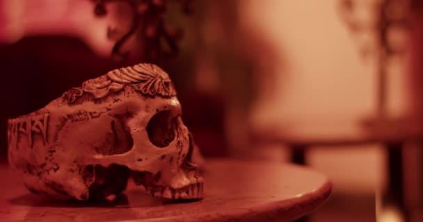 死者の日の夜に暗い部屋のテーブルに置かれた頭蓋骨の稲妻のフラッシュのハンドヘルドショット — ストック動画