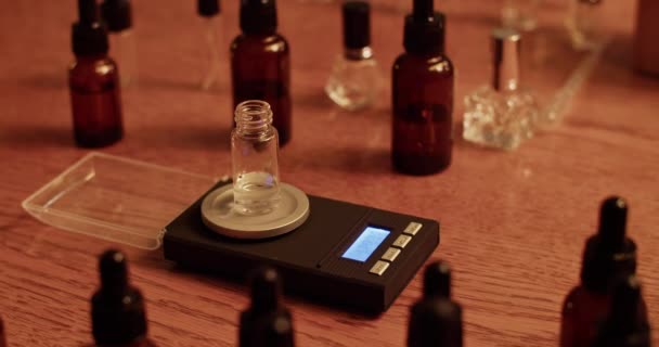 薄暗い実験室で香水を作っている間 スケールの重量を量るために液体に液体を注ぐ作物認識できない化学者の高角度リアルタイム — ストック動画