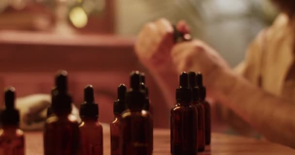 Kesilmiş Erkek Kimyagerin Aromatik Yağla Şişeyi Alıp Pipetle Damlatırken Karanlık — Stok video