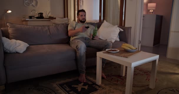 Bărbat Adult Barbă Depresivă Haine Casual Ținând Telecomanda Vizionând Televizorul — Videoclip de stoc