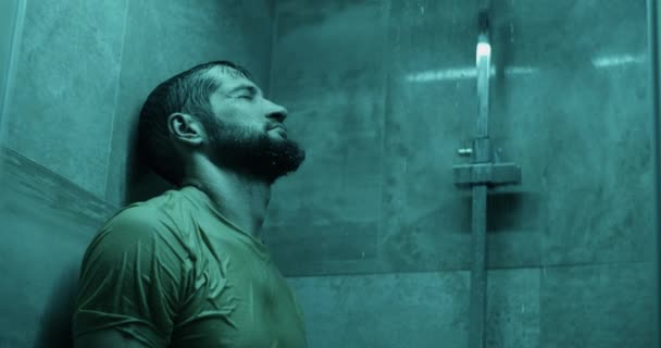 居家浴室淋浴时 身穿休闲服的沮丧大胡子男性侧卧在墙上的侧视图 — 图库视频影像