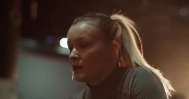 穿着运动服的疲惫的年轻女运动员 在健身房做了紧张的运动后 金发碧眼的她休息了一下 — 图库视频影像