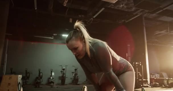 身材苗条的年轻女性在健身房做完剧烈运动后 身穿运动服 双手靠在膝盖上休息 — 图库视频影像