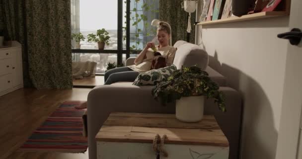 Real Time Barefoot Volwassen Vrouw Met Haarknot Terwijl Zitten Bank — Stockvideo