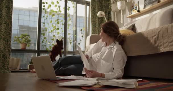노트북 먹이와 바닥에 집에서 서류를 여성의 실시간 — 비디오