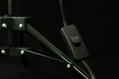 Siyah arkaplanda siyah fotoğraf sehpası lambası anahtarı