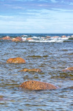 Deniz kenarında mavi dalgalar ve kayalar