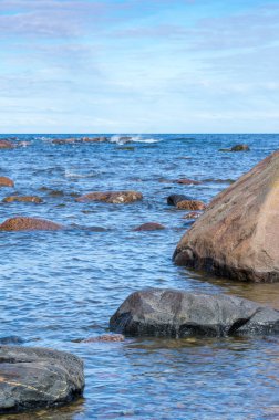 Deniz kenarında mavi dalgalar ve kayalar