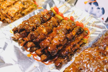 Skewered BBQ beef fillet with sauce on the foil