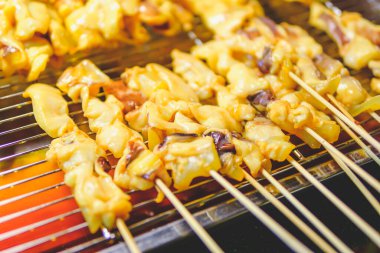 grilled squid skewers  that is roasting on the stove