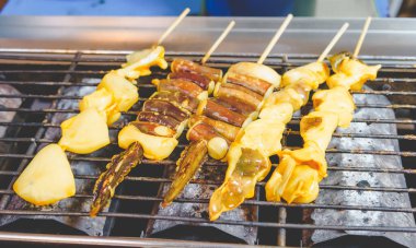 grilled squid skewers  that is roasting on the stove