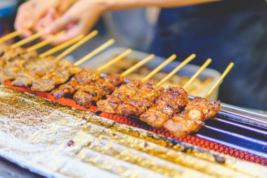 grilled beef skewers  that is roasting on the stove