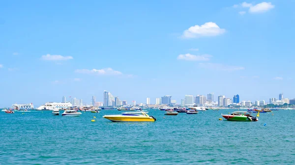 stock image Many speed boats floating in the middle of the sea with a city background