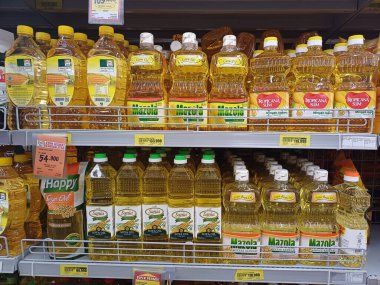Endonezya 'da çeşitli pişirme yağı markalarının bulunduğu bir süpermarket rafı tüketicilere birden fazla seçenek sunuyor. Bu resim market alışverişinin özünü yakalar ve müşteriler için çeşitli gıda ürünleri seçeneklerini vurgular