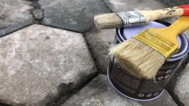 Tahta bir masada kavanozda boya fırçası.