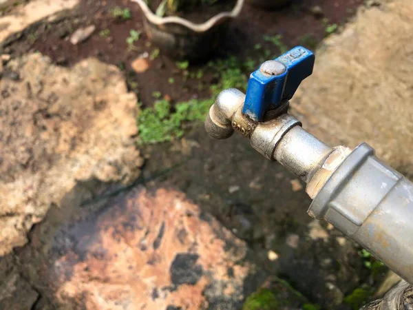 old pipe with a valve and a white water tap