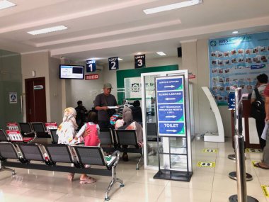 Yolcular tren istasyonunda kontrol için bekliyorlar.