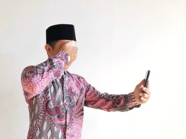 Akıllı telefonu ve cep telefonu olan Müslüman bir adam..