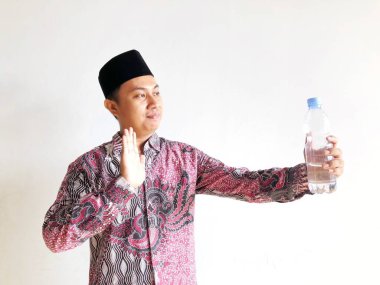 Asyalı Müslüman adam su içmeyi reddediyor.