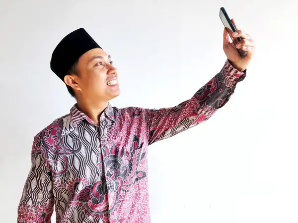 Geleneksel Endonezyalı keung kekeri giyen Asyalı genç adamın portresi