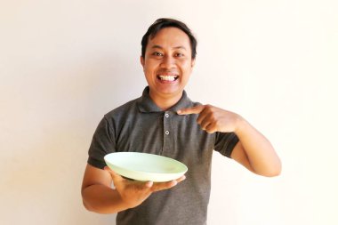 Yeşil gömlekli ve mavi gömlekli mutlu adam beyaz arka planda salatalı kaseyi tutuyor.